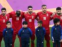 Tim sepak bola Iran berbaris selama lagu kebangsaan sebelum pertandingan 21 November. 