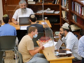 Israeli Yeshiva students are picture at their learning centre separated by barriers to insure that social distancing measures imposed by Israeli authorities meant to curb the spread of the novel coronavirus are being respected, in Tel Aviv on July 7, 2020.
