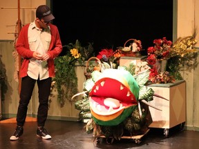 Seymour played by Avery Ikede (L), Voice of Audrey II played by Kaitlyn Maczuszenko (R), Puppeteer of Audrey II played by Katherine Justin (R), during All Saints Catholic High School's Cappies production of Little Shop of Horrors, on Nov. 24, 2022