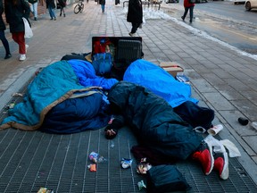 Three homeless men are seen sleeping on Rideau Street the week before Christmas.