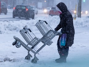A woman struggles with a shopping cart during the winter storm just before Christmas. People got through this and other difficulties by helping and listening to each other.