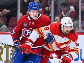 Kaiden Guhle, seen holding back Calgary's Chris Tanev in a game Monday, has one goal and 10 assists in 28 games for Montreal so far this season and has averaged 20:34 of ice time a game.