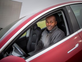 Lawrence Williams with his electric vehicle. His condo’s board denied him permission to continue charging via a parking lot bollard even though he offered to pay more than the regular monthly parking fees to cover electricity costs.