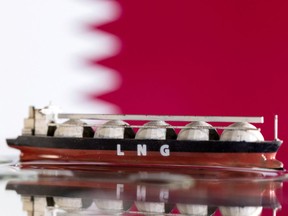 FILE PHOTO: Illustration shows model of LNG tanker and Qatar's flag