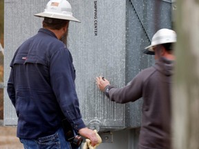 North Carolina energy workers inspect what they said was one of three bullet holes that crippled an electrical substation after the local sheriff said that vandalism caused a mass power outage, in Carthage, N.C.