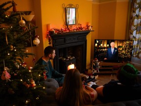A family sits in a living room in Liverpool, as they watch Britain's King Charles III delivering his first annual Christmas Day message, on television, on December 25, 2022.