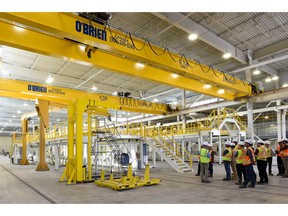 Workers inspect huge overhead cranes inside the Belfast Road facility where the city's Alstom Citadis Spirit LRT trains were assembled.