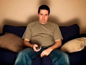 Bored, lazy, overweight man sits on the sofa - stock photo
getty