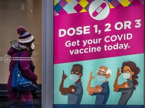 A pedestrian walks past a Covid 19 vaccination poster in Toronto in a photo taken in February.