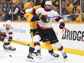Ottawa Senators centre Dylan Gambrell (27) battles with Nashville Predators defenceman Mattias Ekholm (14) for a puck during the second period at Bridgestone Arena, Dec. 10, 2022.