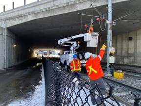 Workers at the site of a mechanical failure in the overhead wiring of the O-Train near Lees station on December 18, 2022.