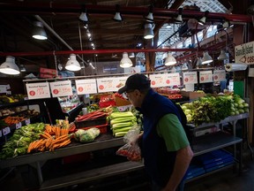A person shops for produce at the Granville Island Market in Vancouver.