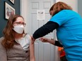 Dr Nili Kaplan-Myrth, at right, gives a COVID shot in Ottawa Monday afternoon.