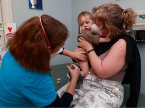 Dr. Nili Kaplan-Myrth gives a COVID-19 vaccine shot to nine-month-old Fredrik in Ottawa Monday afternoon. Fredrik's mom, Line Loennum, holds her son during the shot.