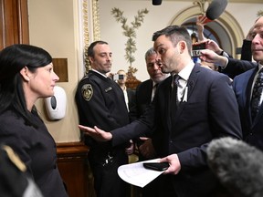 Parti Québécois Leader Paul St-Pierre Plamondon, centre, speaks to the sergeant-at-arms Véronique Michel, who prevented the three PQ elected members to enter the Blue Room at the legislature in Quebec City, Thursday, Dec. 1, 2022. The three PQ members refused to swear an oath to the King. St-Pierre Plamondon is flanked by Pascal Berubé, left, and Joël Arseneau.