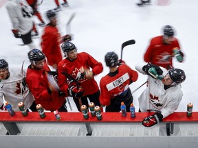 Members of Canada's National Junior Team take a water break during a training camp practice in Calgary, Tuesday, Aug. 2, 2022. Moved from last December and January to August because of COVID-19, the postponed and reimagined 2022 world junior hockey championship presented unique challenges.