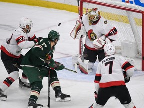 Ottawa Senators goalie Anton Forsberg (31) stops a shot as centre Claude Giroux (28) tries to clear Minnesota Wild left wing Marcus Foligno and Ottawa Senators left wing Brady Tkachuk (7) looks on from the goal during the first period of an NHL hockey game, Sunday, Dec. 18, 2022, in St. Paul, Minn.