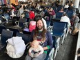 Michael Wortman and his infant daughter in Toronto's Pearson airport on Thursday, Dec. 22 as they wait to get on a standby flight. Wortman and his family are attempting to get to Newfoundland but missed their earlier connection.