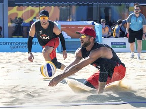 Canada's Dan Dearing returns the ball as teammate Sam Schachter looks on in the men's beach volleyball competition against Australia at the Commonwealth Games in Coventry, England, on Sunday, Aug. 7, 2022.