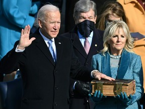 Joe Biden, flanked by Jill Biden, takes the oath of office as the 46th U.S. president on Jan. 20, 2021, at the U.S. Capitol in Washington, D.C.