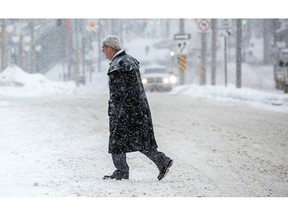 OTTAWA - A man trudges through snow in downtown Ottawa on  Sunday, Jan. 29, but expect a reprieve on Monday, with the forecast calling for only a few flurries. ASHLEY FRASER/Postmedia