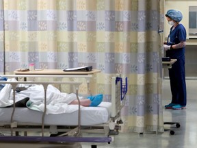 A nurse tends to her patient within one of the COVID- 19 units at the Queensway Carleton Hospital, APRIL 28, 2020.