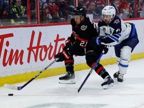 Ottawa Senators right wing Mathieu Joseph (21) and Winnipeg Jets defenceman Josh Morrissey (44) during first period NHL action at the Canadian Tire Centre on Saturday, Jan. 21, 2023.