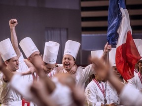 Members of the French team : (LtoR) Joffrey Lafontaine, Mathieu Blandin (hidden), Quentin Bailly and Frederic Cassel, celebrate with their trophy after winning the final of the World Cup of pastries, on January 28, 2013 during the catering and food international show (SIRHA), in the French central town of Chassieu, near Lyon.