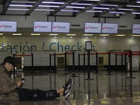 A passenger waits in an empty terminal at the airport while flights are suspended due to drug cartel-related violence in Culiacan, Sinaloa state, Mexico on Jan. 6, 2023.