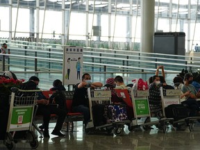 Passengers sit at the departure hall in Hong Kong international airport in Hong Kong, Friday, Sep. 23, 2022.&ampnbsp;Ottawa plans to temporarily require people flying from China, Hong Kong and Macao to test negative for COVID-19 before leaving for Canada, beginning in early January.