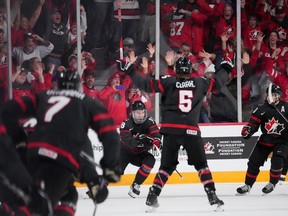 Canada's Connor Bedard, centre, reacts with teammates after scoring the game-winning goal in overtime of IIHF World Junior Championship quarterfinal action against Slovakia in Halifax, Monday, Jan. 2, 2023.
