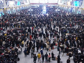 FILE PHOTO: Travellers wait for their trains at Hangzhou East railway station during the Spring Festival travel rush ahead of the Chinese Lunar New Year, in Hangzhou, Zhejiang province, China Jan. 20, 2023.