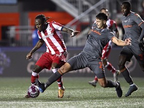 Forge FC's Alessandro Hojabrpour (21) battles for possession with Atletico Ottawa's Ballou Tabla (13) during second half Canadian Premier League finals soccer action in Ottawa on October 30, 2022.