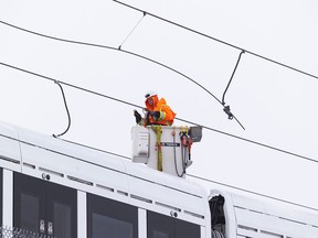 Vendredi, un travailleur poursuit les réparations des câbles aériens sur la ligne LRT entre les stations Hurdman et Lees.