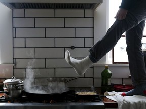 Jorge Sanhueza-Lyon stands on his kitchen counter to warm his feet over his gas stove during a snow storm on Feb. 16, 2021, in Austin, Texas. Following comments made by a member of the Consumer Product Safety Commission on Jan. 9, 2023, misleading claims that the Biden administration is planning on banning gas stoves have spread widely across social media platforms.