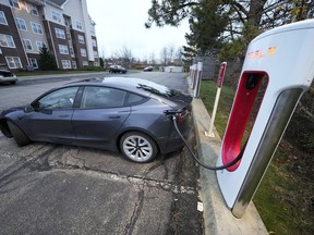 FILE - A Tesla sedan gets a charge at a Tesla Supercharging station in Cranberry, Pa, Wednesday, Nov. 16, 2022. With its sales slowing and its stock price tumbling, Tesla Inc. slashed prices dramatically Friday on several versions of its electric vehicles, making some of its models eligible for a new federal tax credit that could help spur buyer interest.