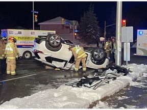 Firefighters work to remove the side doors on a vehicle in a crash Tuesday night.