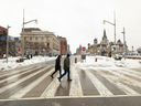 Pedestrians cross Wellington Street this week. It remains largely empty, cordoned off by concrete barriers and largely devoid of people. PHOTO BY TONY CALDWELL /Ottawa Citizen