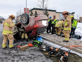Firefighters extricate a driver in a rollover at the Trainyards area Saturday.