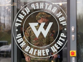 FILE PHOTO: A man wearing a camouflage uniform walks out of PMC Wagner Centre, which is a project implemented by the businessman and founder of the Wagner private military group Yevgeny Prigozhin, during the official opening of the office block in Saint Petersburg, Russia, November 4, 2022.