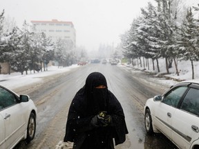 An Afghan woman begs on a snowy day in Kabul, Jan. 29. While millions of Afghans face hunger, the Taliban leadership is focused on reviving their theocratic dystopia of the 1990s.