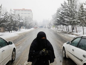 An Afghan woman begs on a snowy day in Kabul, Jan. 29. While millions of Afghans face hunger, the Taliban leadership are focused on reviving their theocratic dystopia of the 1990s.