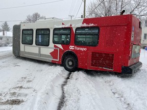 An articulated OC Transpo bus is stuck in the winter snow in December.