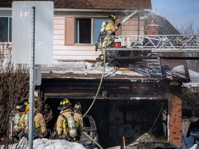 Ottawa firefighters work to put out a garage fire on Larkin Drive on Sunday, Feb. 12, 2023.
