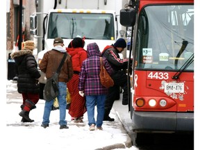 A crowd of people get on board an OC Transpo bus during the COVID-19 pandemic.