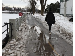 A person walks along the slushy Rideau Canal