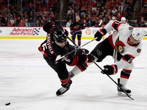 Jalen Chatfield (#5) of the Carolina Hurricanes and Mathieu Joseph (#21) of the Ottawa Senators battle for possession during the third period of the game at PNC Arena on Feb. 24, 2023 in Raleigh, North Carolina.