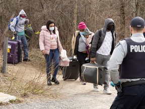 FILE PHOTO: Asylum seekers cross into Canada from the U.S. border near a checkpoint on Roxham Road near Hemmingford, Quebec, Canada April 24, 2022.