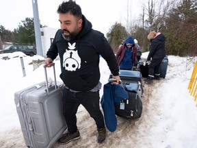 A family of asylum seekers from Colombia crosses the border at Roxham Road into Canada, Thursday, February 9, 2023 in Champlain, NY. THE CANADIAN PRESS/Ryan Remiorz