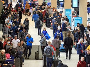 Hundreds of WestJet passengers line up as they wait to rebook cancelled flights at the Calgary International Airport on December 20, 2022.